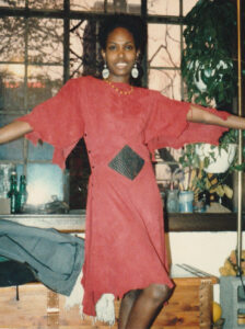 Sherie wearing red chamois dress with black leather inserts, showing the front.