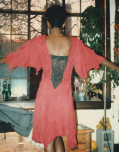 Sherie wearing red chamois dress with black leather inserts, showing the back.